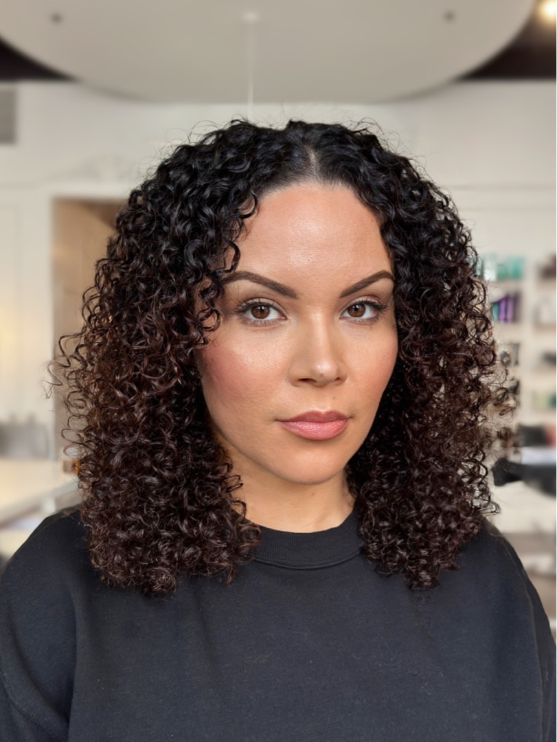 A client at Moe's Beauty Co. mid-transformation, curl-by-curl